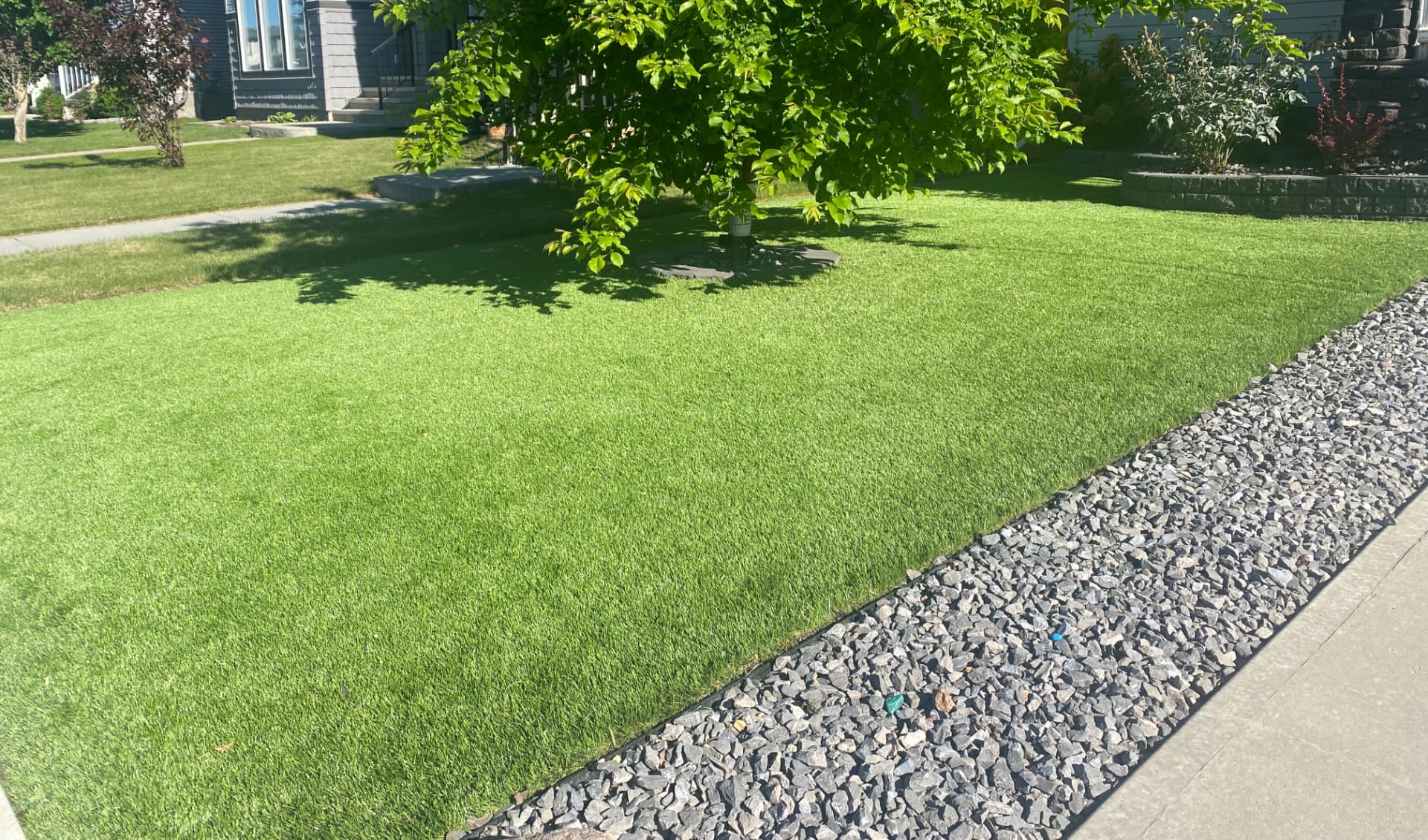 Artificial turf lawn with stone steppers in a residential backyard