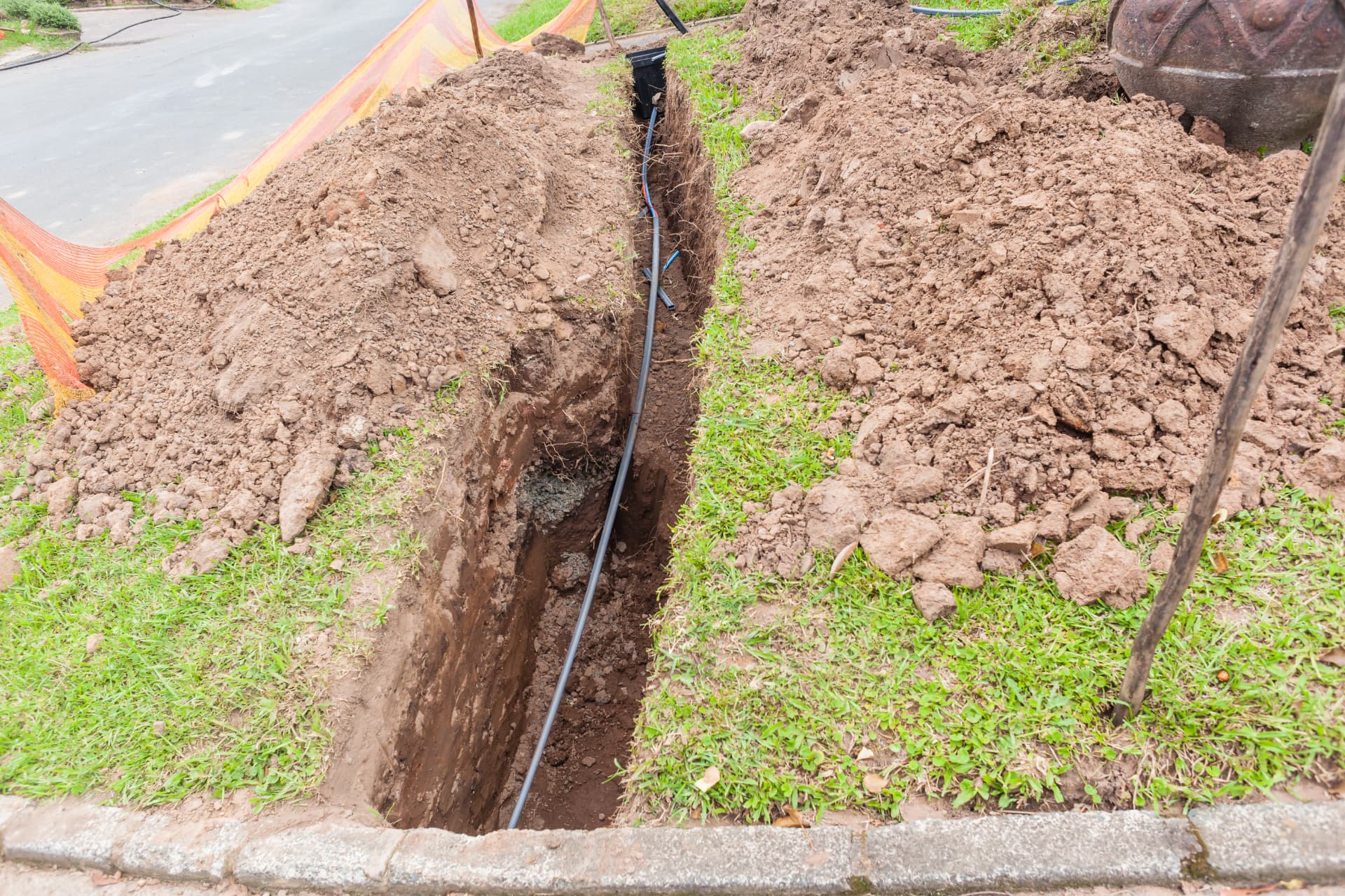 Drainage trench installation with buried pipe and compacted soil in Richardson, Texas